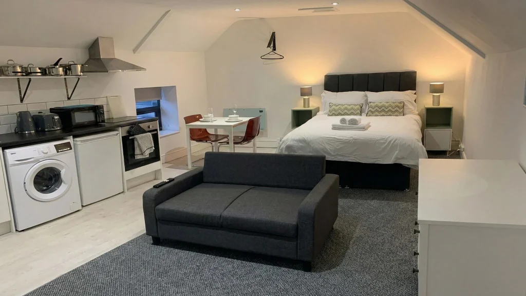 Comfortable double bed and peaceful seating area in Studio 6 of serviced apartments Hereford