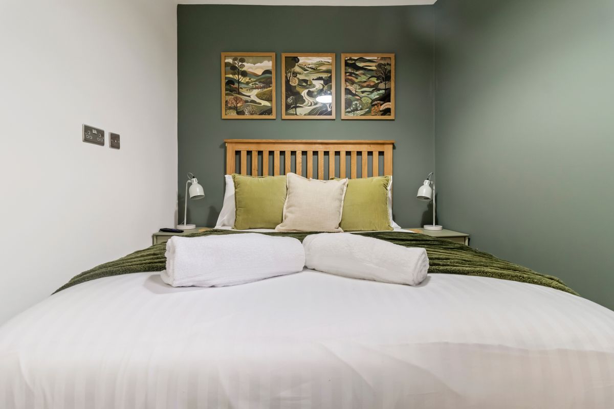 Spacious Worcester serviced apartment living area with equipped kitchen and seating