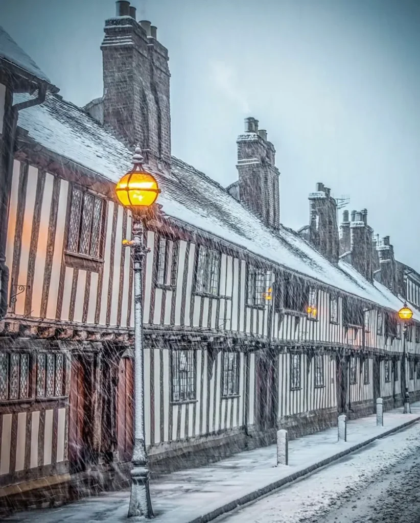 Beautiful snow-covered streets in a UK city during winter, showcasing the magic of a snowy cityscape.